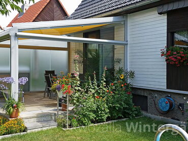 Terrassenüberdachung aus Alu und rahmenlosen Glaselementen zum Teil aus Milchglas - KWOZALLA Wintergärten in Sachsen
